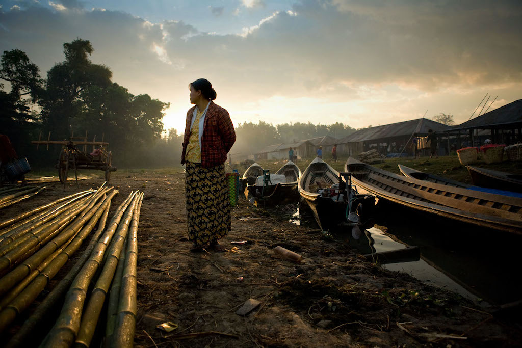 A woman stands at the boat docks at a market in Inlay Lake, Burma.  (Photo by Robb Elliot/Momenta Workshops)